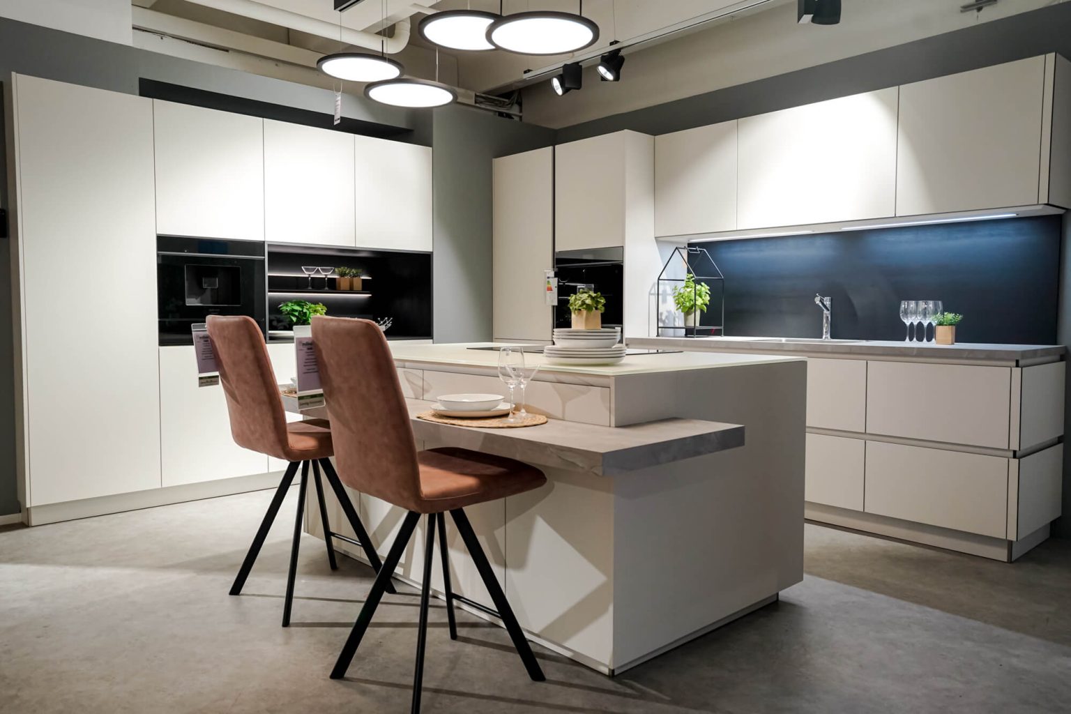 Moderne Inselkueche mit Bartresen Weiss